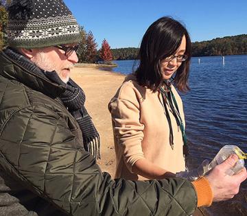 Two scientists look at a water sample collected at the Upper Oconee watershed
