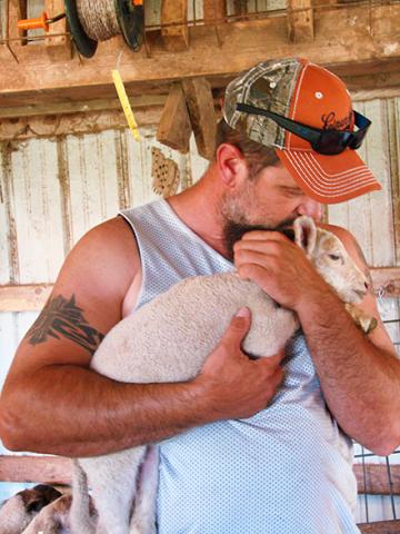 A veteran holding a lamb