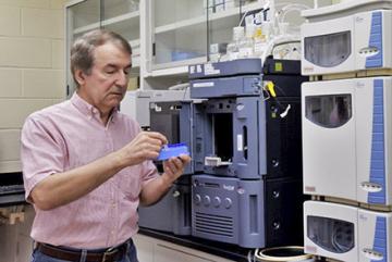 A scientist inserting a tray of samples into a lab machine