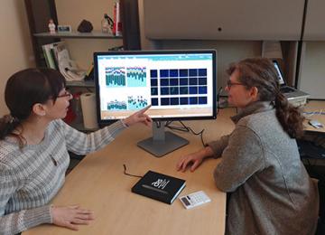ARS scientists review microscope images and data on a computer screen