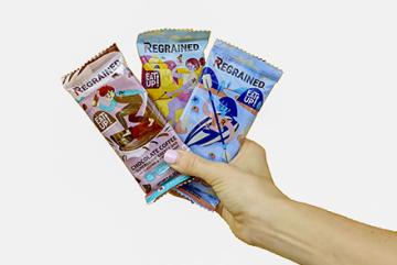 A hand holding three packaged ReGrained bars.