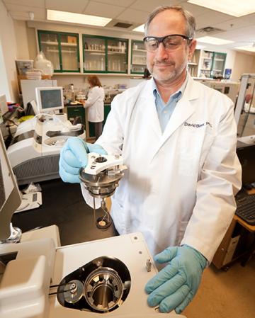 David Baer working with diet study samples in a laboratory.