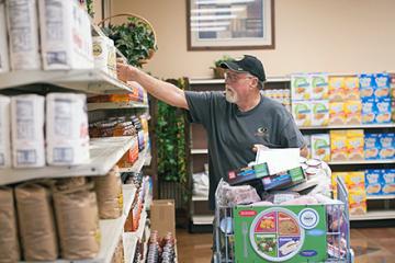 A man reaching for a grocery item on a shelf