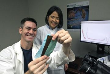 Two scientists examine copper oxide nanoflower cotton fabrics at different stages of the production process