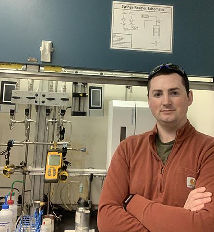 ARS research chemical engineer Evan Wegener in front of chemical reactors in the lab. (Photo courtesy of Evan Wegener)