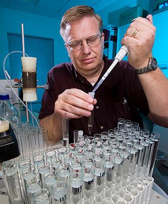 Soil scientist preparing water samples of reclaimed water used for irrigation.