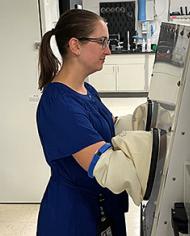 ARS molecular biologist Karley Mahalak in front of an anaerobic chamber 