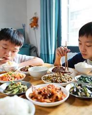 Two Chinese boys eating a traditional meal. 